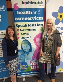two Healthwatch champions with a Healthwatch display stand
